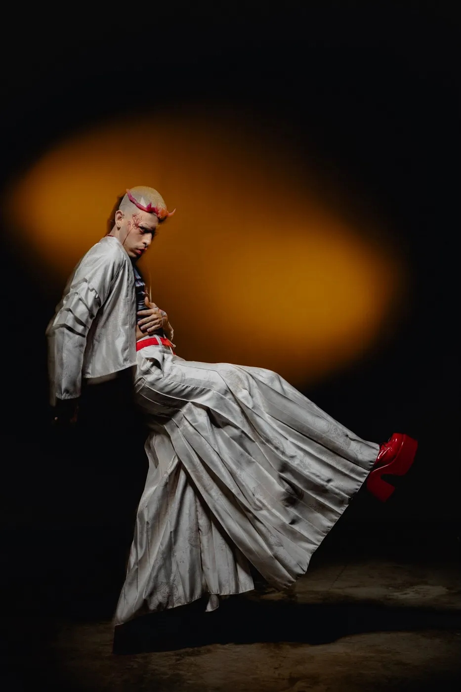 APEREIRA studio campaign: Grey jacket and pleated skirt, seated