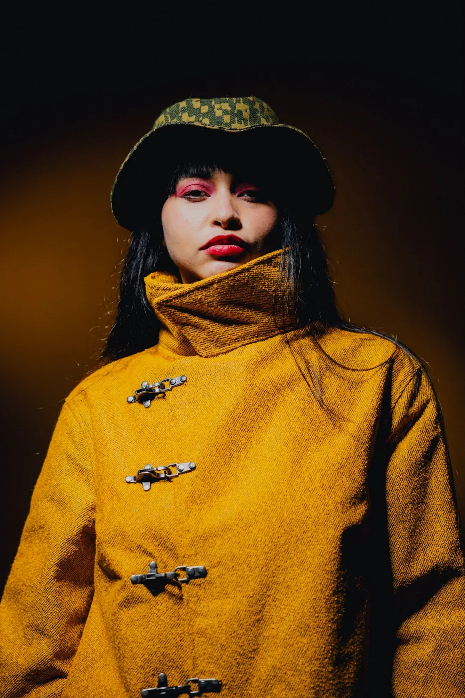 APEREIRA studio campaign: Mustard coat with metal clasps